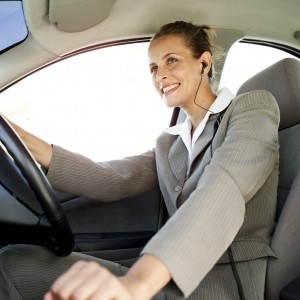 Woman Driving a Car and Wearing Earphones --- Image by © Royalty-Free/Corbis